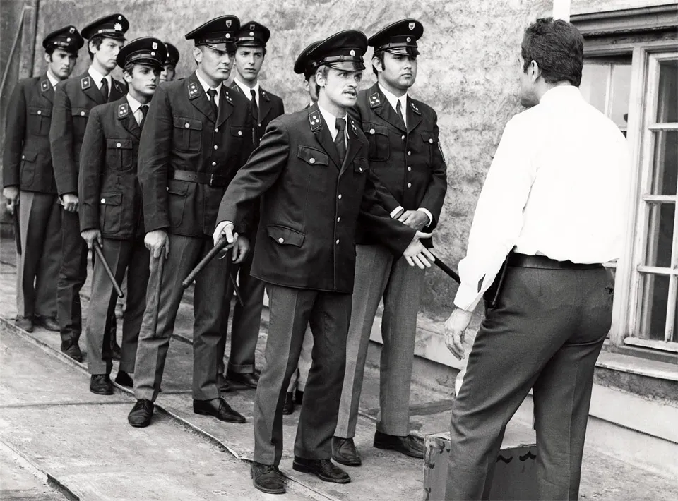 Standfoto für - Nicht fummeln Liebling ! - mit der Polizeiausbildung und Hans Fries von hinten als Ausbilder Müller vor einer Gruppe Polizisten bei der Schlagstockausbildung in einer Münchner Polizeischule