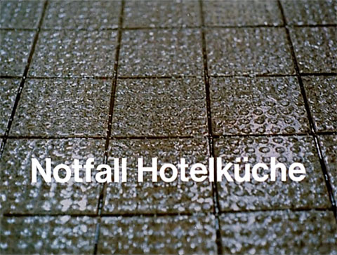 Titelbild des Kurzfilmes „Notfall Hotelküche“ mit einem nass-glänzendem, grau-braunem Fliesenboden, Teil 4 aus der Erste-Hilfe-Serie "Rette mich, wer kann"