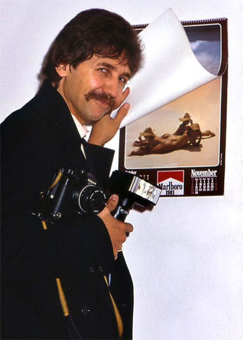 Fotograf Mike Gallus mit einer Nikon-Spiegelreflexkamera und einem Blitz-Gerät
