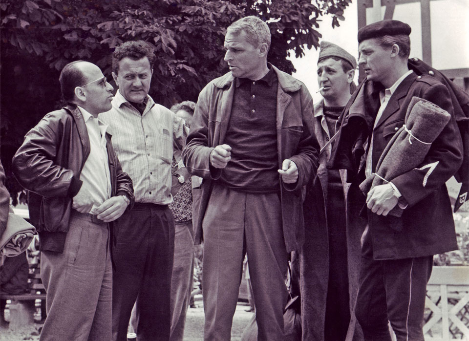 Besprechung bei Dreharbeiten zum Spielfilm "Jenseits des Rheins“, eine deutsch-französisch-italienische Coproduktion 1960, mit den Schauspielern Georges Rivière und Charles Aznavour, Regisseur André Cayatte, Aufnahmeleiter Hans Fries und einem weiteren Crew-Mitglied