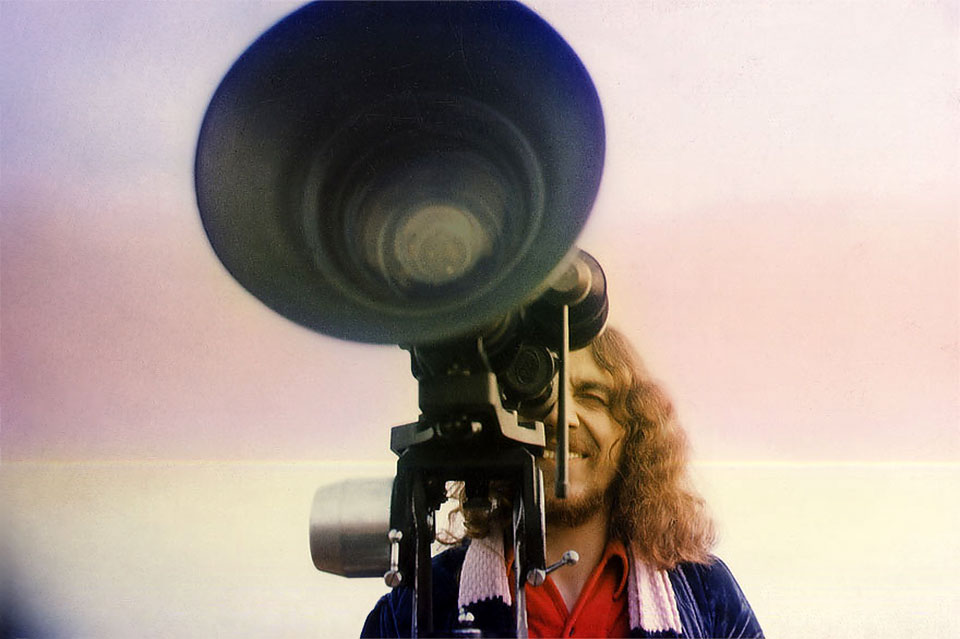 Foto von Michael Gallus bei Dreharbeiten zu seinem Abschlußfilm „Astral“ an einer seinerzeit zukunftsweisenden schweizer Bolex 16 Pro Kamera mit Power-Zoom (der sogenannten Gummilinse) auf einem Sachtler Stativ mit neig- und schwenkbarem Kreiselkopf