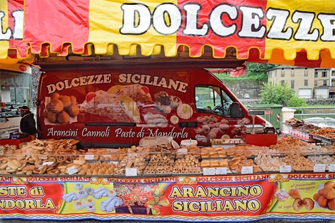Offener Verkaufswagen auf dem Markt in Ponte Tresa mit sizilianischem Süßgebäck (Dolcezze Siciliane) wie zum Beispiel Arancino Siciliano
