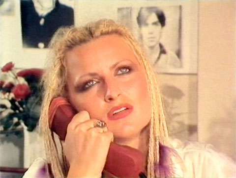 Ginny Enroe am Telefon in einer Szene der Film-Satire "Knips mich Studio Guten Tag“ von Mike Gallus