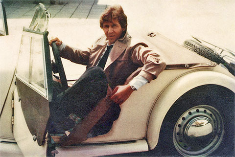Mike Gallus 1980 in seinem hellbeigen Morgan Plus 8 Roadster