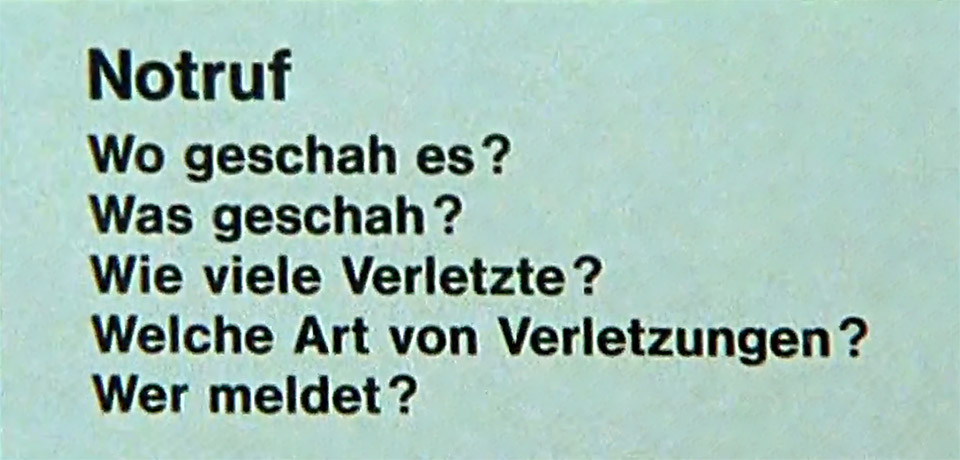 Merktafel aus dem Erste-Hilfe-Film „Rette mich wer kann - Notfall Halle 3“ mit den 5W-Fragen für den Notruf: Wo geschah es ? Was geschah ? Wie viele Verletzte ? Welche Art von Verletzungen ? Wer meldet ?